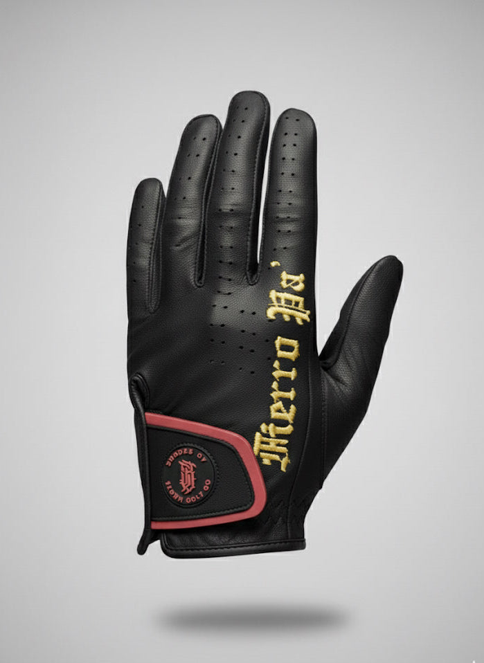 Black golf glove with red and gold accents on a gray background