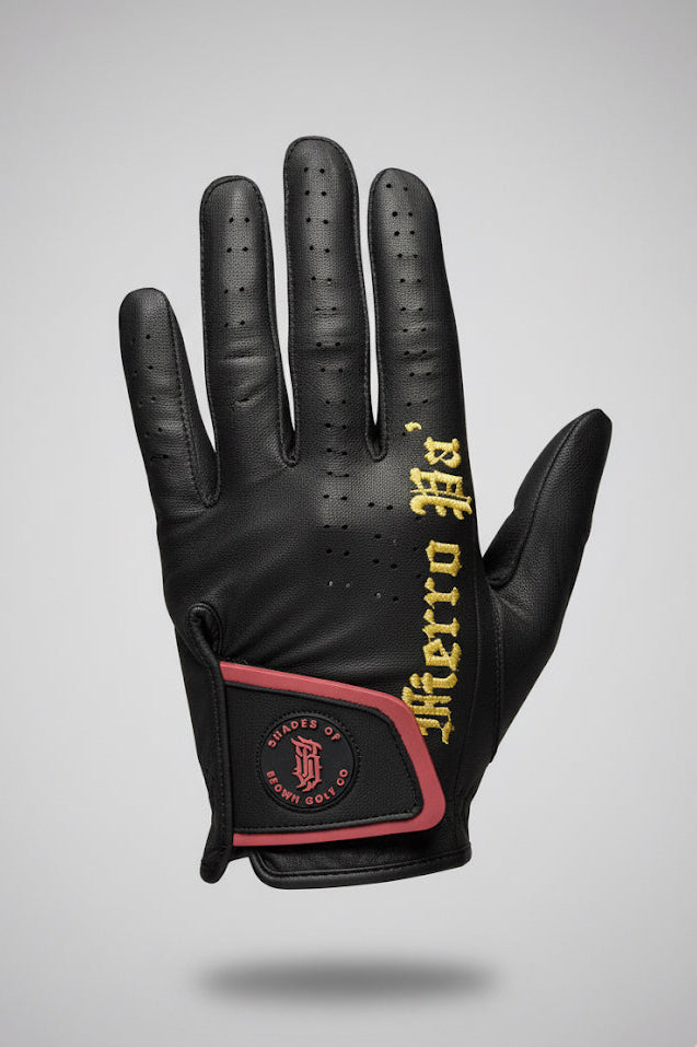 Black leather glove with yellow text and red accents on a gray background